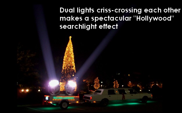 Hollywood searchlight rental: two searchlights on a trailer crossing their beams over a lighted holiday tree