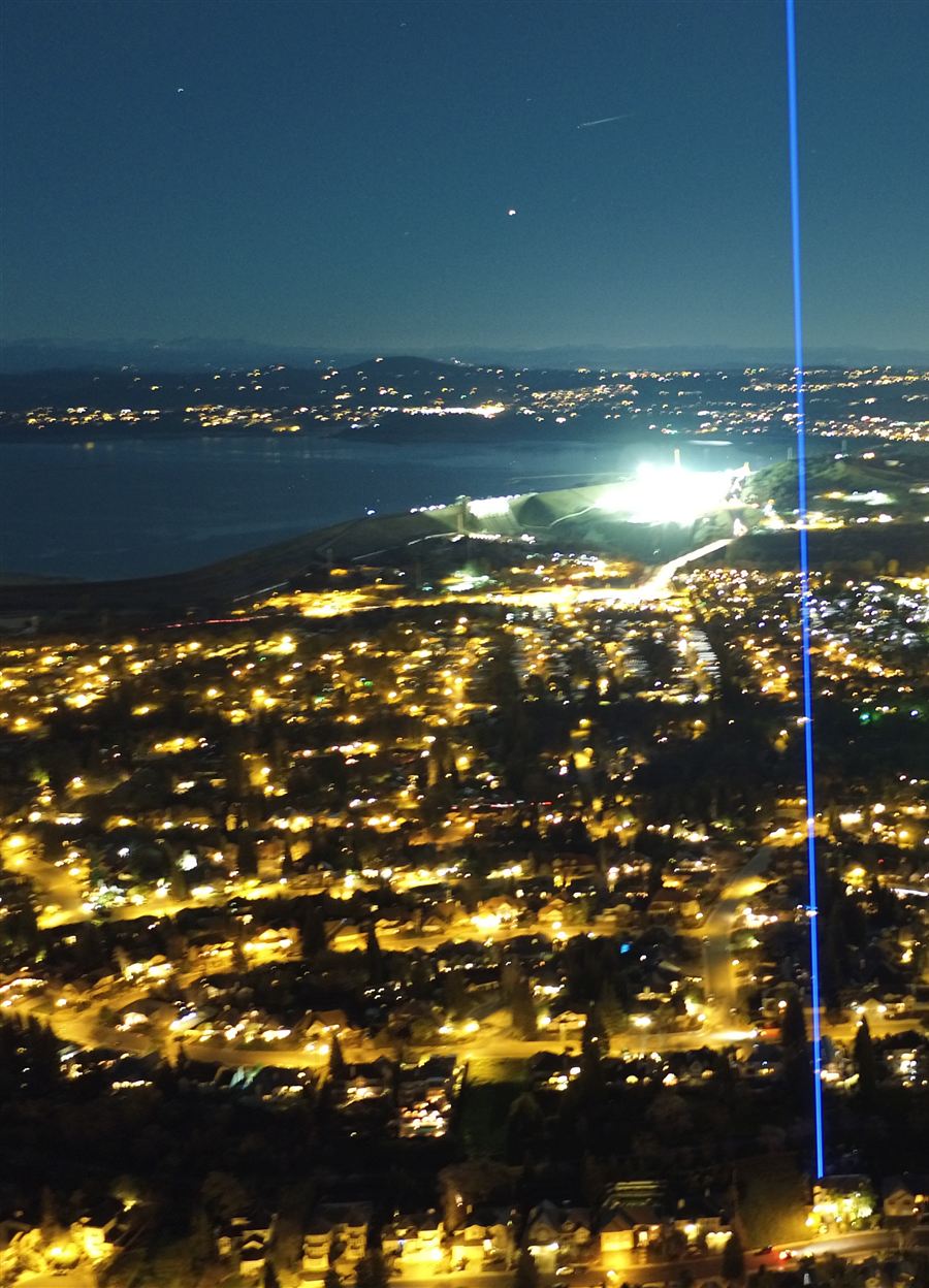 Laser searchlight rental: a blue beam over a city at night