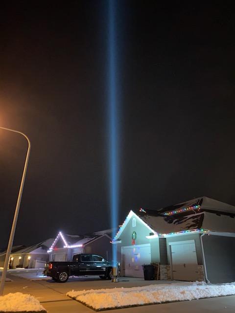 Single-beam searchlight rental lighting the sky at a home party
